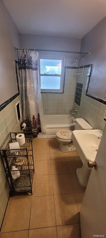 full bath with tile patterned flooring, tile walls, toilet, and shower / bath combo with shower curtain