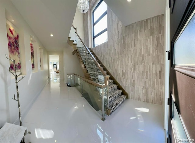 staircase with an accent wall, recessed lighting, and tile walls