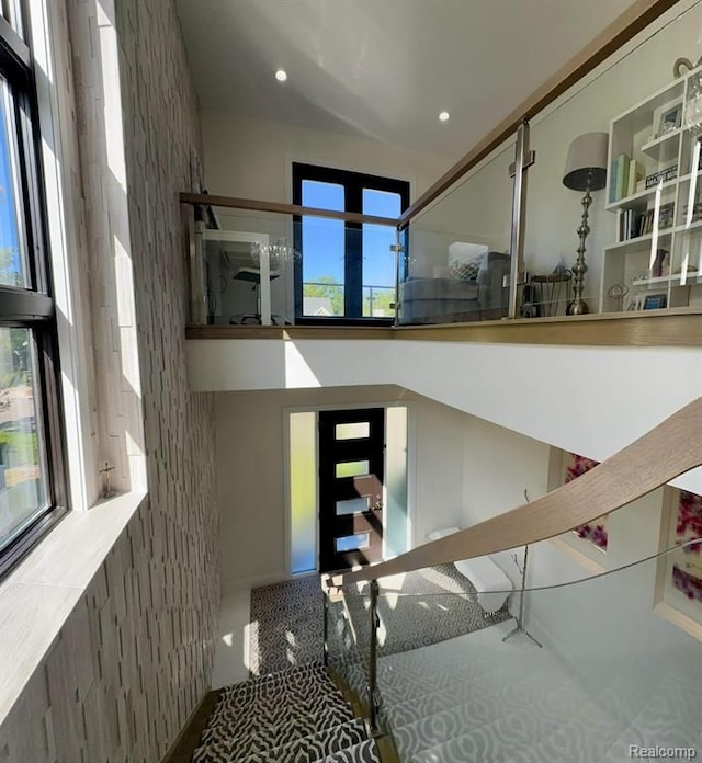 stairs with a towering ceiling and recessed lighting