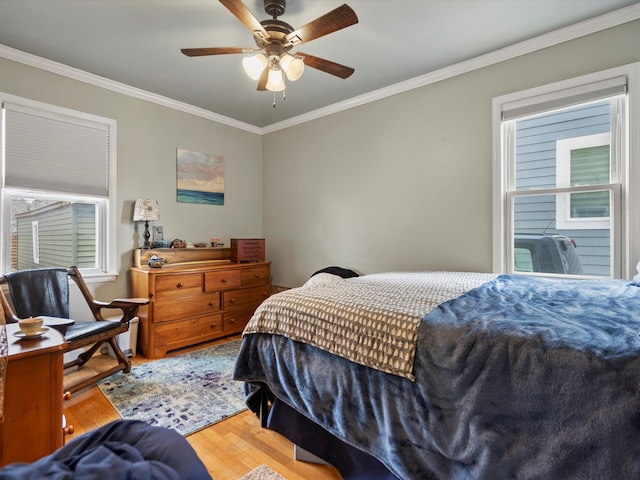 bedroom featuring ceiling fan, ornamental molding, and wood finished floors