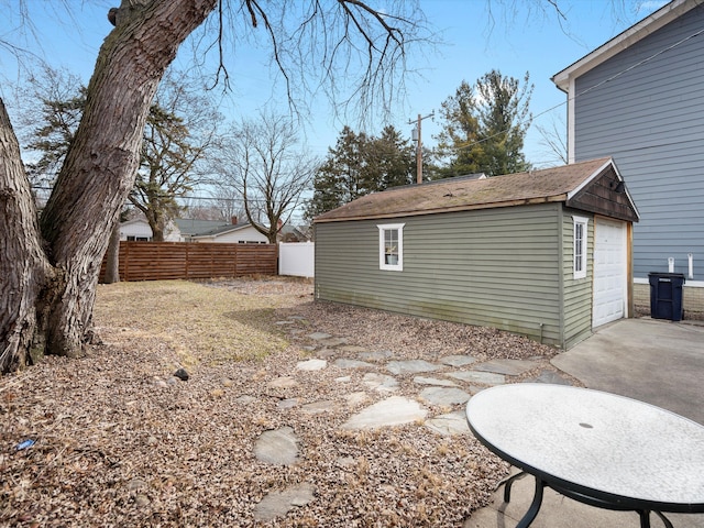 view of yard featuring driveway, an outdoor structure, and fence