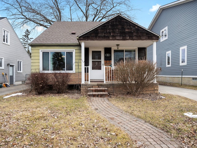 bungalow-style house with covered porch and roof with shingles