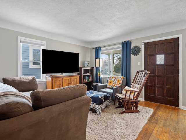 living area with a textured ceiling and wood finished floors