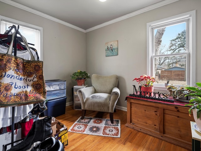 sitting room featuring baseboards, wood finished floors, and crown molding