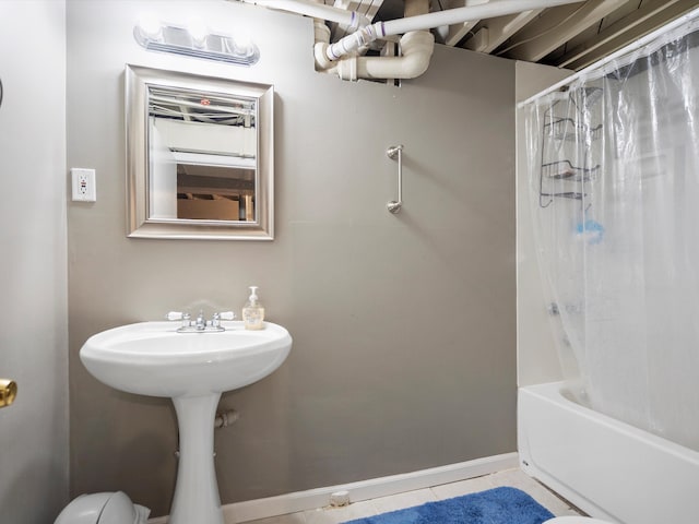 full bath featuring tile patterned flooring, baseboards, and shower / bath combo