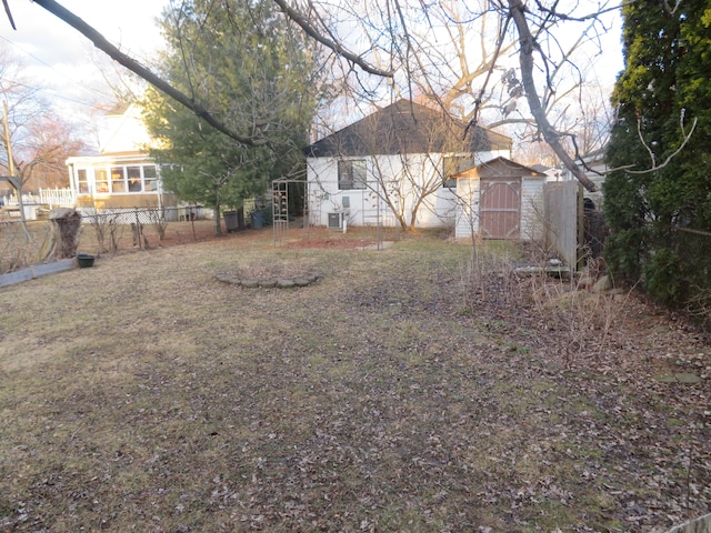 view of yard featuring a storage shed, an outbuilding, and fence