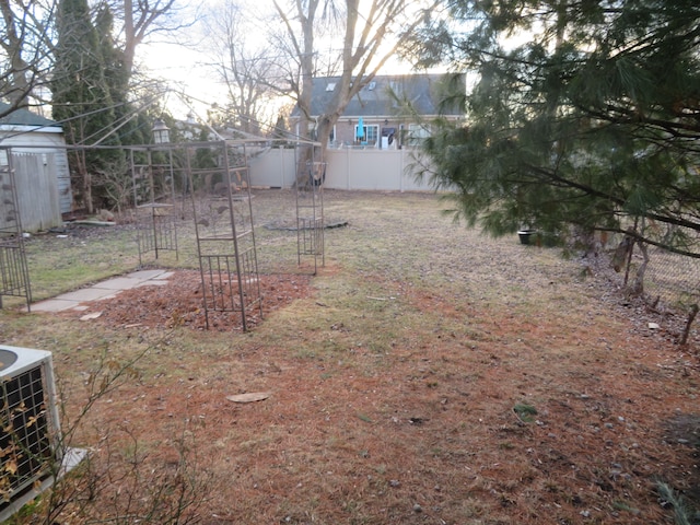 view of yard featuring central AC unit and fence