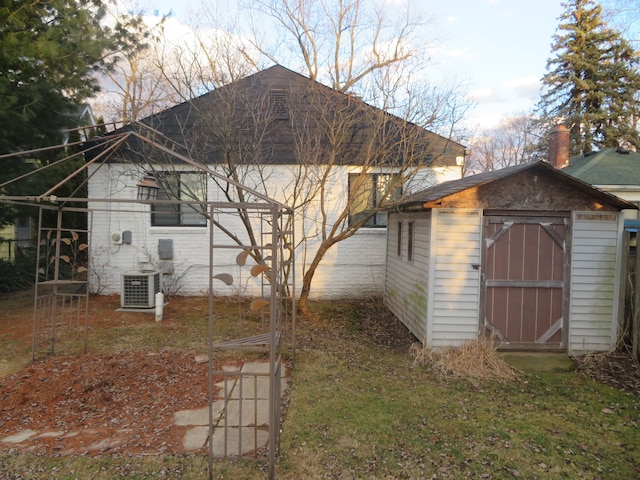 exterior space with an outbuilding, a storage unit, and cooling unit