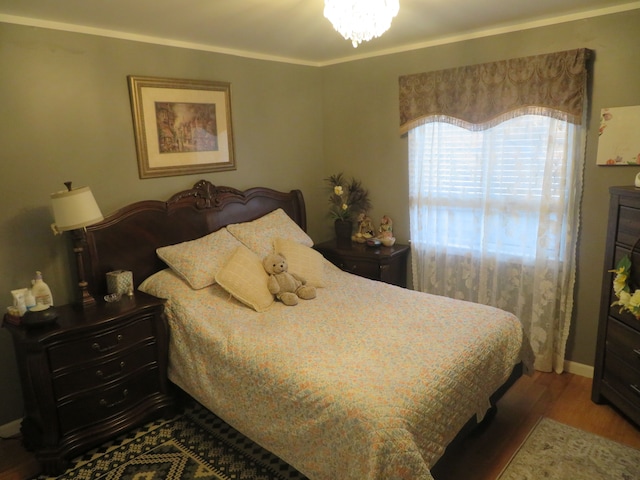 bedroom featuring an inviting chandelier and wood finished floors