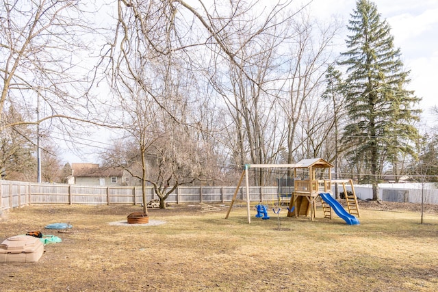 view of yard featuring an outdoor fire pit, a playground, and a fenced backyard