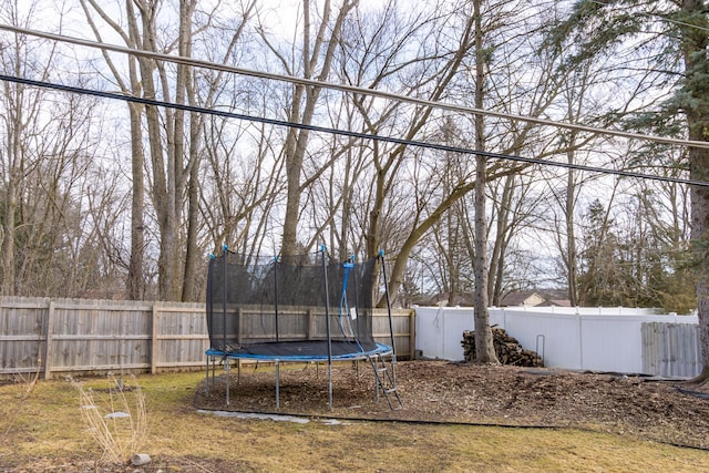 view of yard with a trampoline and a fenced backyard