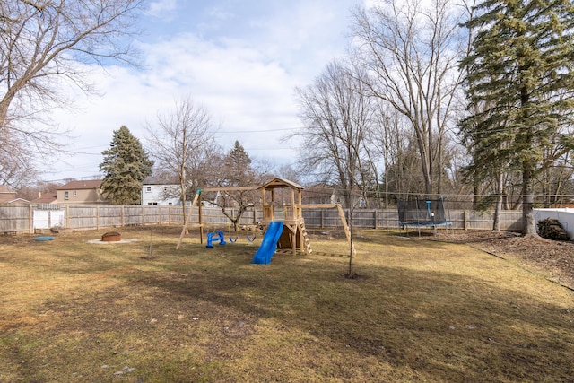 view of yard featuring a trampoline, a playground, and a fenced backyard