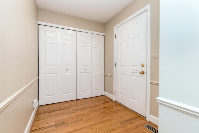 interior space featuring light wood-type flooring, baseboards, and visible vents