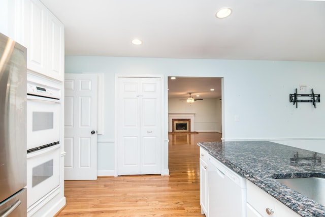 kitchen with white appliances, white cabinets, light wood-style floors, and recessed lighting