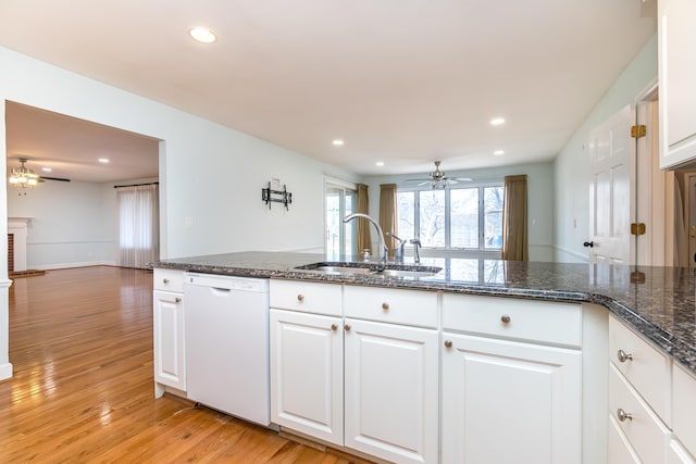 kitchen featuring dishwasher, light wood-type flooring, a sink, and white cabinets