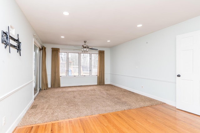 empty room featuring recessed lighting, light carpet, a ceiling fan, baseboards, and light wood-style floors