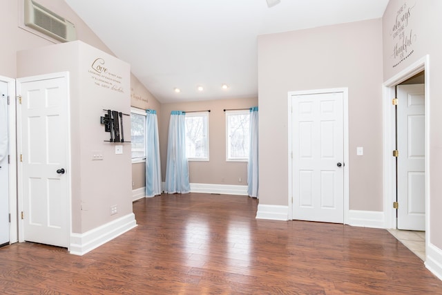 interior space featuring lofted ceiling, wood finished floors, visible vents, and baseboards