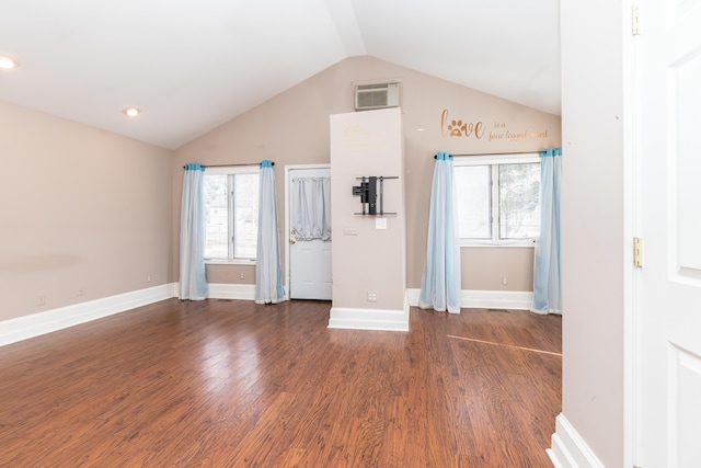 interior space with visible vents, vaulted ceiling, baseboards, and wood finished floors