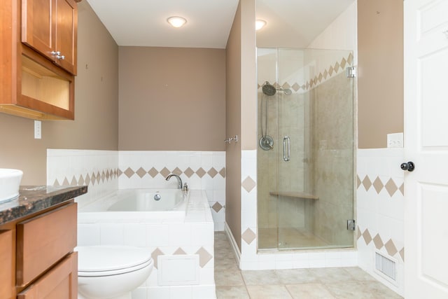 bathroom featuring toilet, vanity, a shower stall, a bath, and tile patterned floors