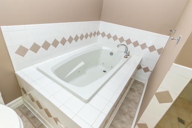 bathroom featuring a tub with jets, toilet, and tile patterned floors