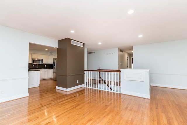 spare room with baseboards, recessed lighting, visible vents, and light wood-style floors