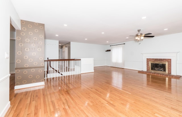 unfurnished living room featuring recessed lighting, a fireplace, wood finished floors, a ceiling fan, and baseboards