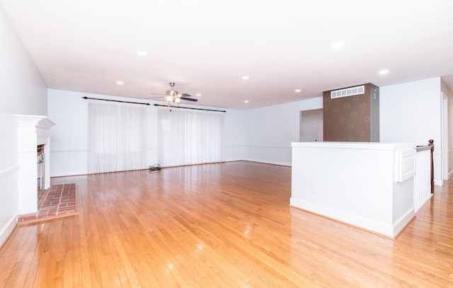 unfurnished living room featuring ceiling fan, recessed lighting, a fireplace, visible vents, and light wood-type flooring