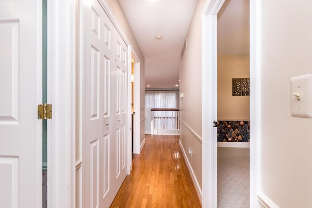 hallway with light wood finished floors and baseboards