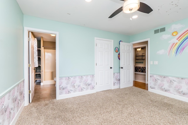 unfurnished bedroom featuring carpet floors, a ceiling fan, visible vents, and baseboards