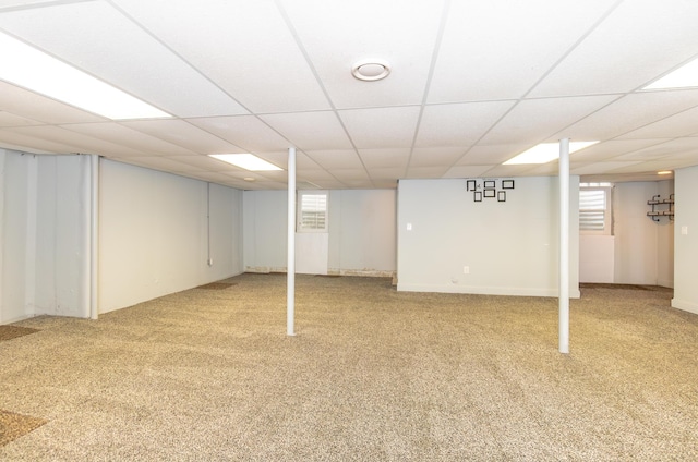 below grade area with light carpet and a paneled ceiling