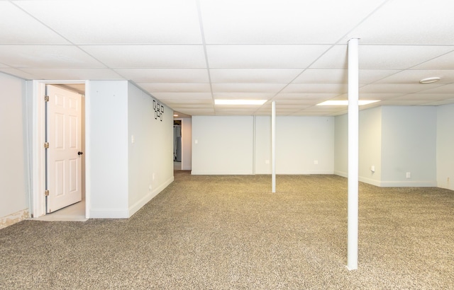 finished below grade area with carpet floors, a drop ceiling, and baseboards