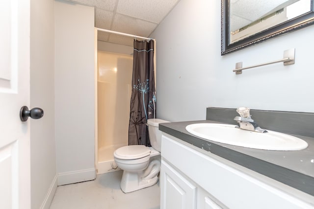 bathroom featuring vanity, a drop ceiling, a shower stall, and toilet