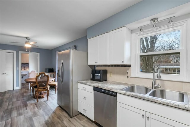 kitchen featuring appliances with stainless steel finishes, light countertops, white cabinets, and a sink