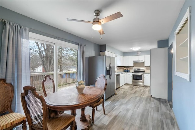 dining space featuring light wood finished floors and a ceiling fan