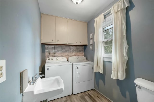 laundry room featuring laundry area, light wood finished floors, independent washer and dryer, and a sink