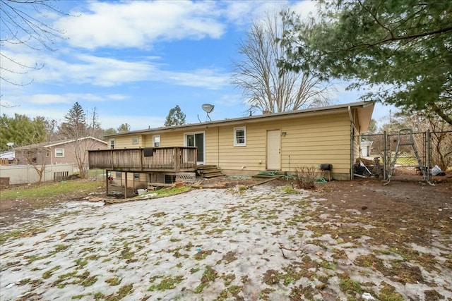 rear view of house featuring fence and a wooden deck