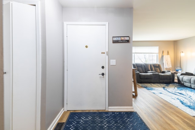 entryway featuring visible vents, baseboards, and wood finished floors