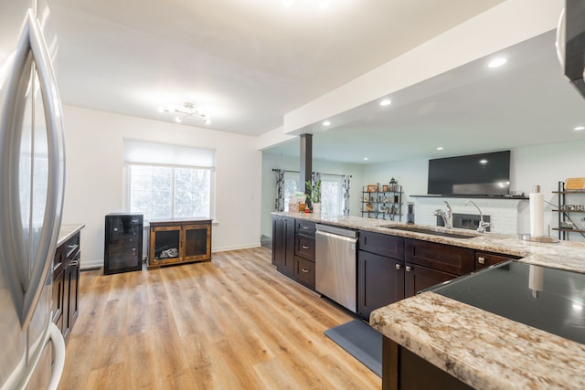 kitchen featuring light wood-style flooring, a healthy amount of sunlight, appliances with stainless steel finishes, and a sink