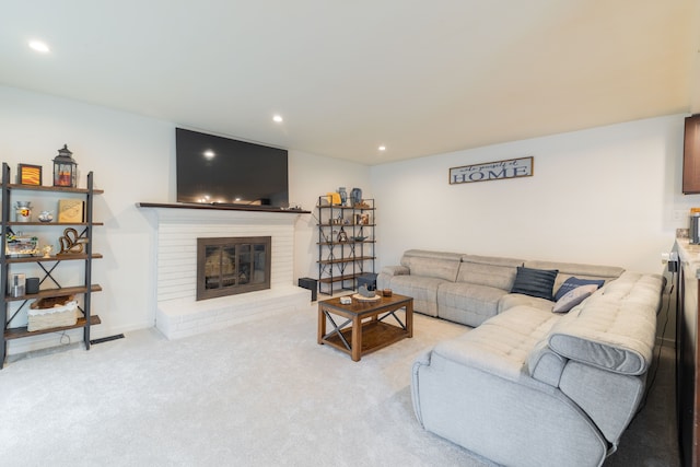 living room with recessed lighting, baseboards, light carpet, and a brick fireplace