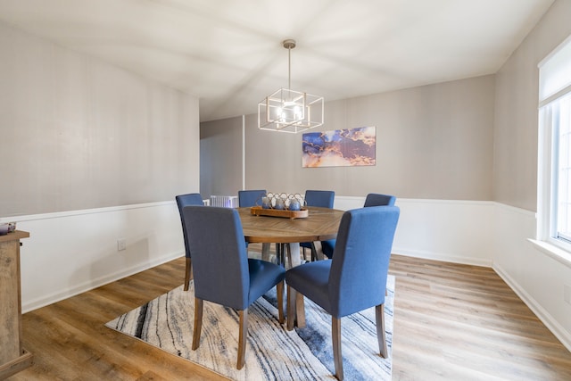 dining area featuring a chandelier, baseboards, and wood finished floors