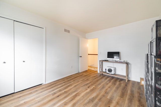 unfurnished living room featuring visible vents and wood finished floors