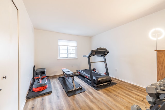 workout area featuring wood finished floors and baseboards