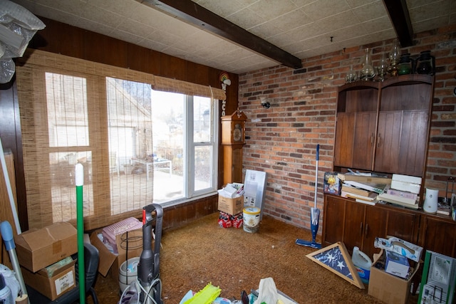 interior space with brick wall and beam ceiling