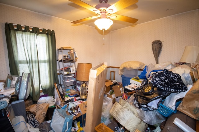 interior space with a ceiling fan and wallpapered walls