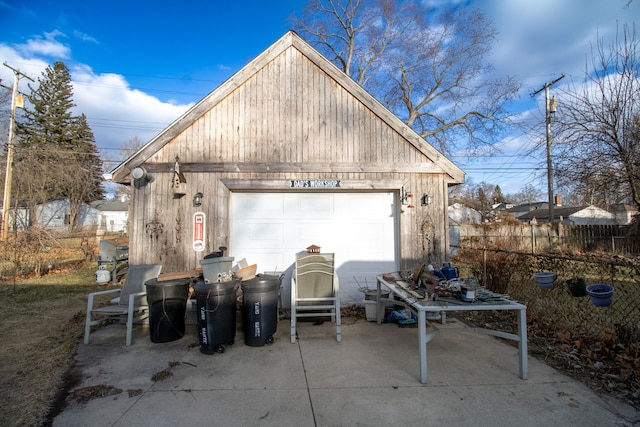 exterior space with an outbuilding, a detached garage, and fence