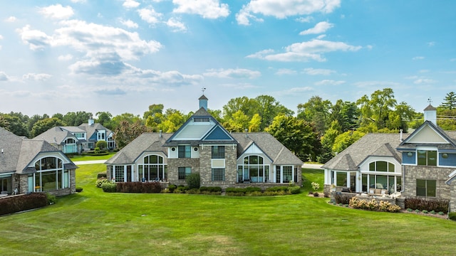 view of front facade featuring stone siding and a front lawn