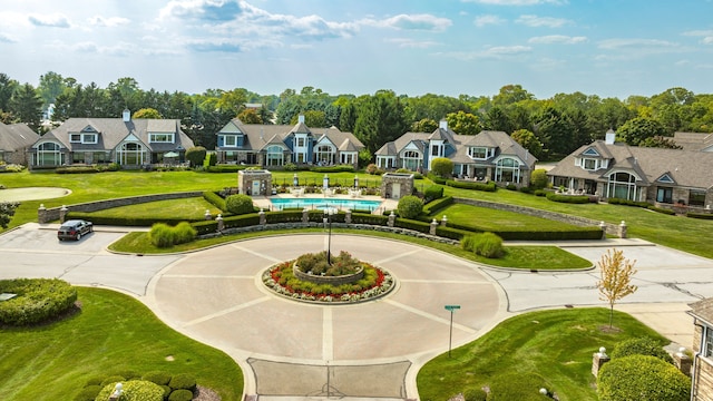 view of home's community featuring a yard, curved driveway, and a residential view