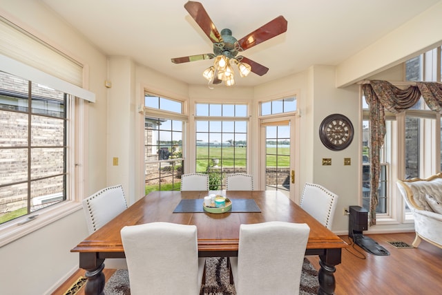 dining space featuring wood finished floors, visible vents, and baseboards