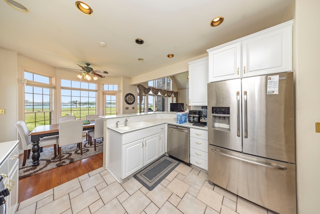 kitchen featuring a peninsula, white cabinetry, appliances with stainless steel finishes, and recessed lighting