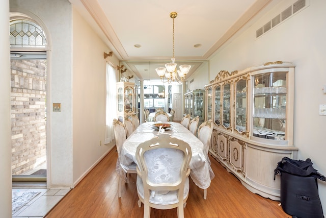 dining room featuring light wood-style flooring, visible vents, a chandelier, and ornamental molding